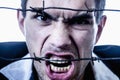 I hate social norms! Man screaming behind a barbed wire as symbol of  readiness to fight. Royalty Free Stock Photo