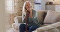 I have all the time in the world to think. a senior woman sitting alone on the sofa at home and looking contemplative Royalty Free Stock Photo