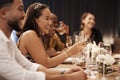 I have the best group of friends. an attractive young woman sitting and enjoying a New Years dinner party with friends.