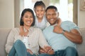 I have the best parents in the whole world. a young couple sitting on their sofa at home with their daughter.