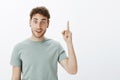 I have great idea, listen. Portrait of positive happy european male model with short curly hair, raising index finger in Royalty Free Stock Photo