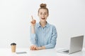 I have great idea. Smart attractive female office manager in stylish glasses, sitting near laptop and smartphone Royalty Free Stock Photo