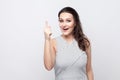 I have an idea. Portrait of amazed beautiful young brunette woman with makeup and striped dress standing and looking at camera Royalty Free Stock Photo