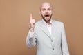 I have idea. Portrait of handsome amazed middle aged bald bearded businessman in classic gray suit standing with finger up and lo Royalty Free Stock Photo