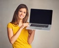 I have just the website for you. an attractive young woman holding a laptop with a blank screen against a grey Royalty Free Stock Photo