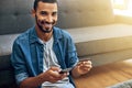 I have no time to go stand in a line. Shot of a focused young man doing online banking with her phone while being seated Royalty Free Stock Photo