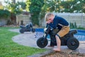 I have nobody to play with. Full length portrait of an adorable little boy crying while riding his toy bike outside.