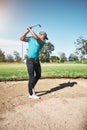 I have to get out of this sand bank. a focused young male golfer about to swing and play a shot with his golf club Royalty Free Stock Photo