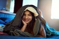 I havent a thing to wear. Portrait of a happy young woman lying under a pile of clothes on her bed. Royalty Free Stock Photo