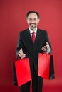I help economy, I shop a lot. Happy shopper red background. Businessman hold shopping bags. Mature man enjoy shopping