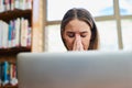 I hope I finish this assignment on time. a young woman looking stressed while sitting behind a laptop. Royalty Free Stock Photo