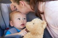 I hope were stopping at the toy store, Mom. a mother kissing her baby boy sitting in a car seat. Royalty Free Stock Photo