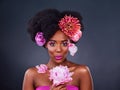 I just cant help but to love flowers. Studio shot of a beautiful young woman posing with flowers in her hair.