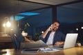 I just finished, Ill be home soon. a handsome young businessman talking on his cellphone while sitting at his desk in a Royalty Free Stock Photo