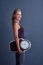 I keep track of my weight. Studio portrait of an attractive mature woman holding a weightscale against a blue background Royalty Free Stock Photo