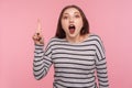 I know answer! Portrait of inspired woman in striped sweatshirt pointing finger up and having good idea