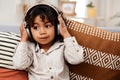 I know a good song when I hear one. an adorable little boy listening to music on headphones while sitting on a sofa at Royalty Free Stock Photo