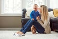 I know just how to cheer him up. a happy young mother playing with her baby boy at home.