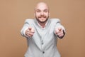 I know you. Portrait of handsome middle aged bald bearded businessman in classic light gray suit standing, pointing and looking Royalty Free Stock Photo