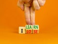 I learn or lose symbol. Concept words I learn and I lose on wooden cubes. Businessman hand. Beautiful orange table orange Royalty Free Stock Photo