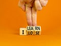 I learn or lose symbol. Concept words I learn and I lose on wooden cubes. Businessman hand. Beautiful orange table orange Royalty Free Stock Photo