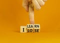 I learn or lose symbol. Concept words I learn and I lose on wooden cubes. Businessman hand. Beautiful orange table orange Royalty Free Stock Photo