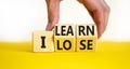 I learn or lose symbol. Concept words I learn and I lose on wooden cubes. Businessman hand. Beautiful yellow table white