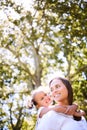 I like hanging out with you. a mother giving her daughter a piggyback ride in the park. Royalty Free Stock Photo