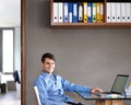 I like having everything neat and tidy in here. Portrait of a confident young businessman sitting at his office desk. Royalty Free Stock Photo