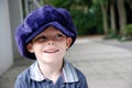 I like pranks, little boy with big violet cap looks around to see who he can fool Royalty Free Stock Photo