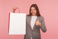 I like shopping! Portrait of happy elegant businesswoman in suit jacket showing thumbs up and holding bags Royalty Free Stock Photo