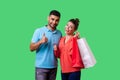 I like shopping. Portrait of satisfied young couple in casual wear showing thumbs up gesture. isolated on green background Royalty Free Stock Photo