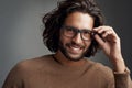 I like what I see. Studio shot of a handsome young man wearing glasses against a gray background. Royalty Free Stock Photo