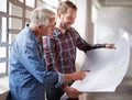 I like what youve done here. two male architects discussing blueprints while standing indoors. Royalty Free Stock Photo