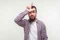 I am loser. Portrait of frustrated bearded man showing loser gesture with L finger symbol. shot on white background