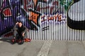 Man sitting near graffiti wall Royalty Free Stock Photo