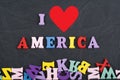 I love America word on black board background composed from colorful abc alphabet block wooden letters, copy space for