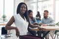 I love being a part of this team. Cropped portrait of an attractive young businesswoman sitting in the office while her Royalty Free Stock Photo