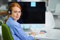 I love being to help people across the globe. Shot of an attractive red headed woman looking over her shoulder in Royalty Free Stock Photo