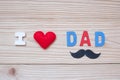 I Love DAD text with red heart shape and mustache on wooden background. Happy Father`s Day and International Men`s Day concepts