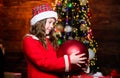 I love decorating christmas tree. Festive atmosphere christmas day. Girl santa claus costume hold big ball christmas Royalty Free Stock Photo