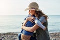 I love him with my whole heart. a loving mother hugging her son while out by the lake.