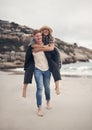 I love how I can be myself with you. a man piggybacking his girlfriend while walking on the beach. Royalty Free Stock Photo