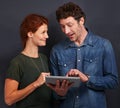 I love how smart he is...a handsome man holding a digital tablet and explaining something to his girlfriend. Royalty Free Stock Photo