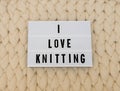 I LOVE KNITTING word on lightbox on knit background. Cozy compozition. Knit WOOL background. Royalty Free Stock Photo