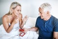 I love it. a mature man gifting his wife with jewellery while relaxing in bed at home. Royalty Free Stock Photo