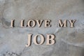 I love my job , writen wooden letters on stone background