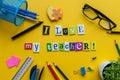 I love my Teacher - text made with carved letters on yellow desk with office or school supplies on pupil table Royalty Free Stock Photo
