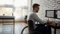 I love my work. Side view of young smiling male engineer or architect in a wheelchair using stylus pen and digital Royalty Free Stock Photo