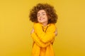 I love myself! Portrait of self-satisfied egoistic curly-haired woman in urban style hoodie embracing herself Royalty Free Stock Photo